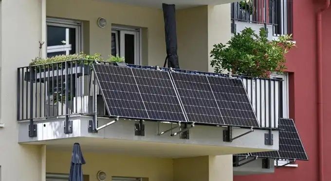 Mehrere Solarmodule sind an den Geländern eines Wohnungsbalkons befestigt