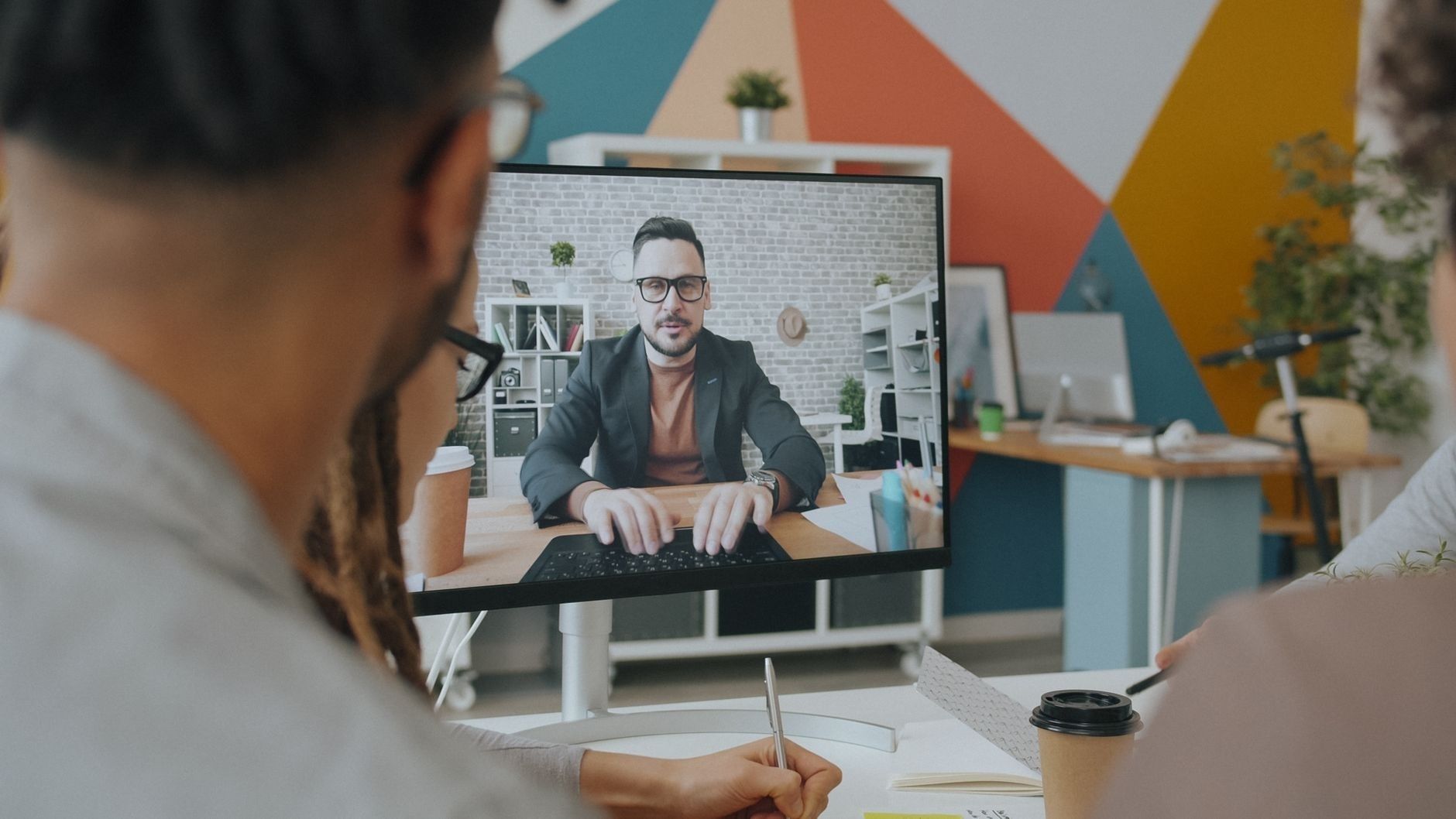 Team bespricht sich per Videokonferenz am Bildschirm im Büro